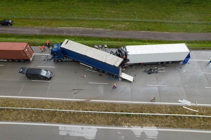 Direct overhead aerial view showing debris and heavy damage after a collision between two trucks on a motorway, Poland, Europe.